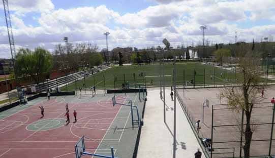 Vista panorámica de las canchas deportivas al aire libre con césped artificial y pistas de baloncesto