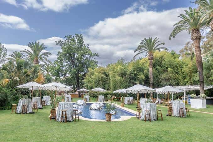 Zona de piscina con mesas y sombrillas para eventos al aire libre