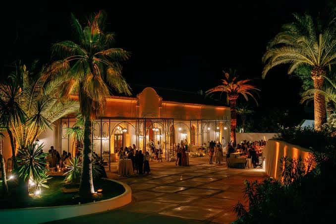 Celebración nocturna en el patio iluminado con invitados