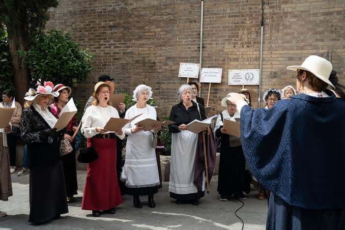 Grupo de personas vestidas con atuendo histórico actuando en el patio del Ateneu