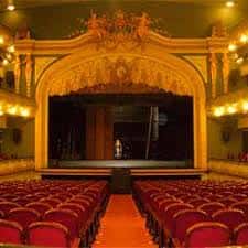 Escenario principal con arco decorativo y butacas en primer plano