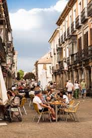 Calle empedrada del Casco Antiguo con terrazas de cafetería y gente disfrutando al aire libre