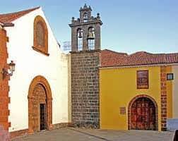 Fachada principal del Antiguo Convento de Santo Domingo de Guzmán con campanario y puerta de madera