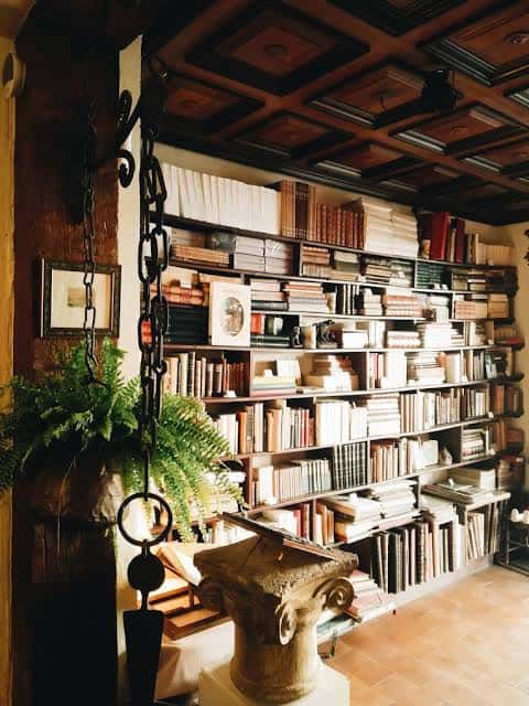 Interior de la Librería Capitel con estanterías llenas de libros antiguos y un techo de madera