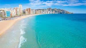 Vista panorámica de la costa de Benidorm con edificios altos y mar turquesa