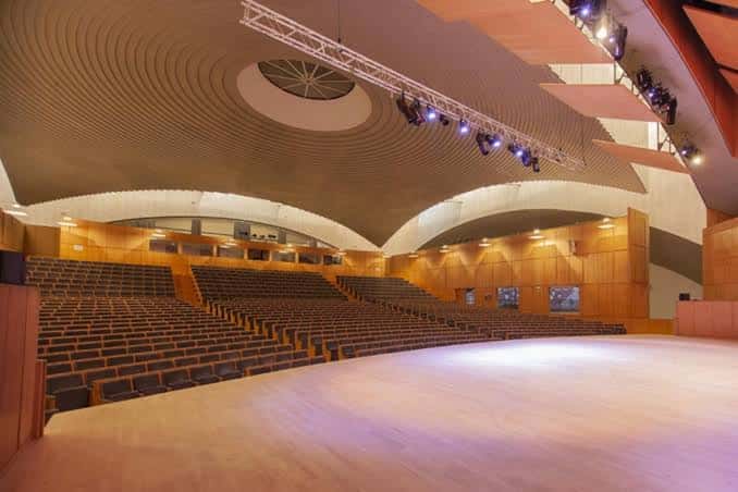 Auditorio vacío con butacas en gradas y sistema de iluminación profesional