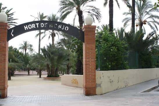 Entrada principal del Hort del Monjo con arco de ladrillo y palmeras