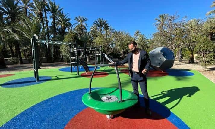 Zona de juegos inclusiva con equipamiento colorido y suelo de caucho en el parque