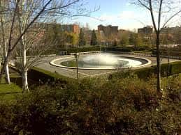 Vista panorámica de la fuente circular rodeada de jardines y árboles