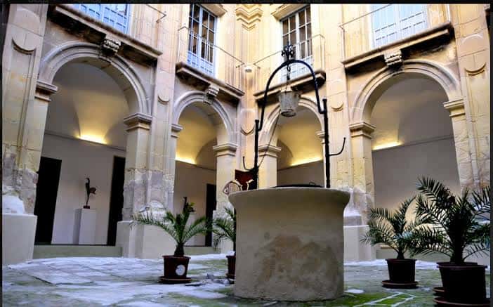 Patio interior con pozo central y arcos iluminados