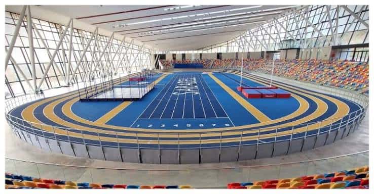 Vista panorámica del interior de la pista de atletismo con gradas multicolores