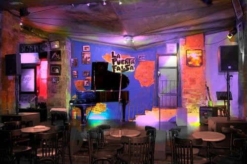 Interior del local La Puerta Falsa con piano y ambiente de evento