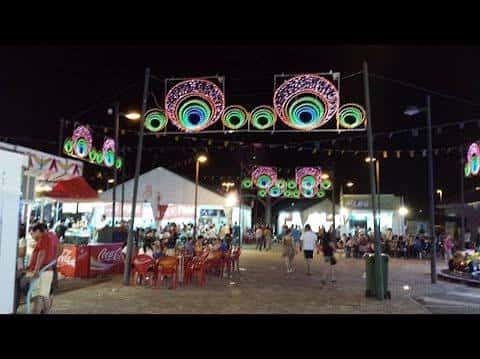 Vista nocturna del Recinto Ferial de La Fortuna con atracciones iluminadas y público disfrutando de las fiestas