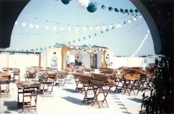 Caseta festiva del antiguo Recinto Colombino decorada con luces y mesas para eventos