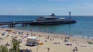 Vista panorámica de la playa de Bournemouth con el muelle y el mar en un día soleado