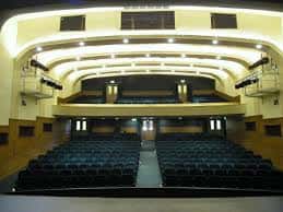 Interior del auditorio del Joseph Rowntree Theatre con butacas azules y balcones curvos