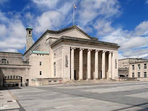 Vista exterior diurna de la fachada neoclásica del O2 Guildhall Southampton con columnas y bandera
