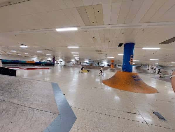 Amplia vista del skatepark con skaters en movimiento