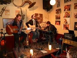 Grupo musical actuando en el interior del Café de Alba con ambiente íntimo y decoración artística