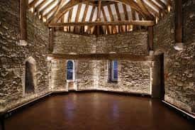 Interior del salón principal con techumbre de madera y paredes de piedra