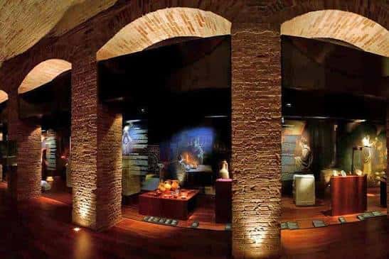 Sala de exposiciones con arcos de ladrillo y vitrinas iluminadas