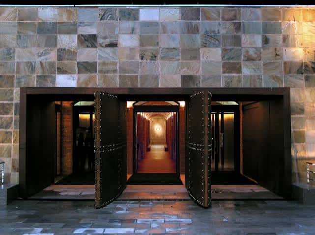 Entrada principal con grandes puertas de madera y fachada de piedra