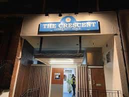 Entrada principal de The Crescent Community Venue con letrero iluminado