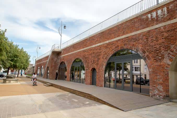 Fachada principal de Hotwalls Studios con arcos de ladrillo y entrada accesible