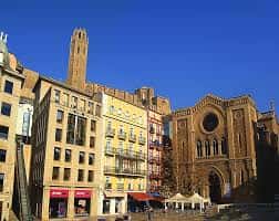 Plaza Sant Joan bajo un cielo azul con arquitectura medieval y moderna