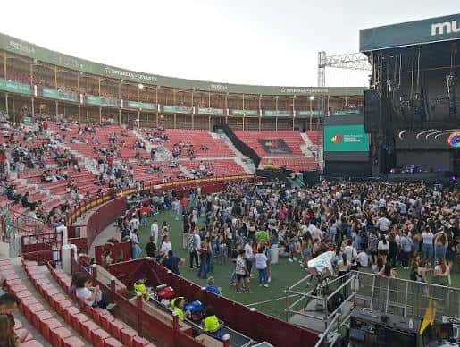 Interior de la plaza durante un evento con público en las gradas y escenario montado