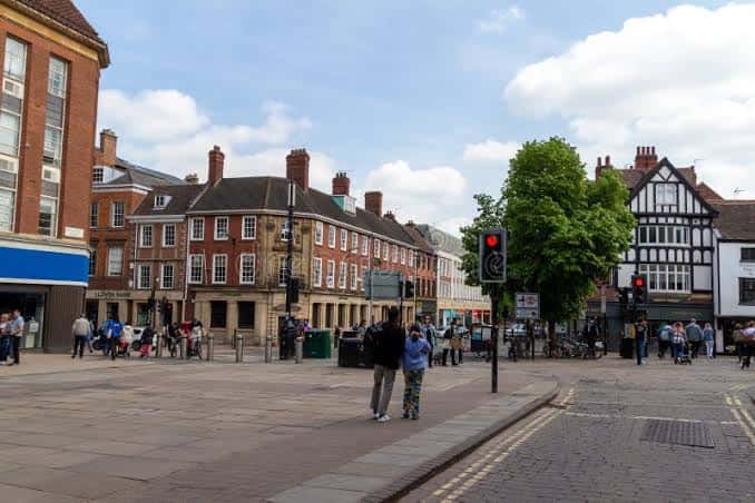Plaza concurrida en Parliament Street con arquitectura tradicional inglesa y semáforos