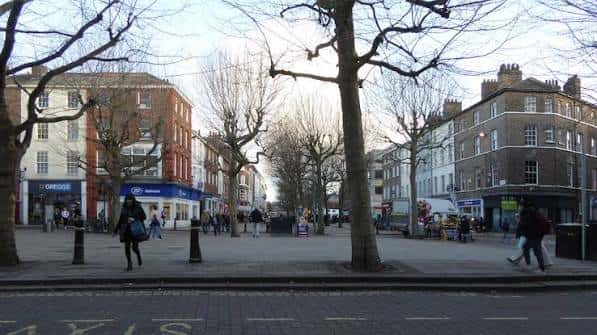 Escena urbana de Parliament Street con peatones y fachadas de edificios del siglo XVIII