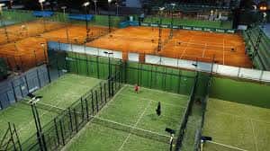 Vista nocturna de las pistas de tenis del club iluminadas