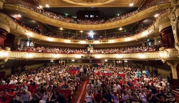 Interior del Kings Theatre con el auditorio lleno de público y balcones ornamentados