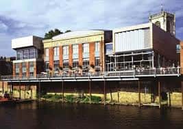Fachada del cine junto al río con terraza al aire libre