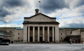 Fachada neoclásica del Guildhall con columnas y bandera en el día