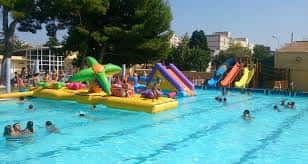 Piscina del Complejo Parque del Oeste con toboganes y gente disfrutando