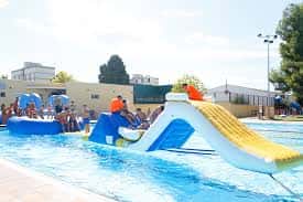 Piscina del Complejo Parque del Oeste con tobogán y personas nadando