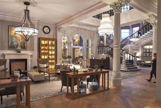 Lobby principal con escalera de mármol y decoración clásica