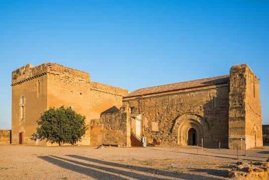 Vista exterior del Castillo Templario de Gardeny con fachada de piedra y cielo azul despejado