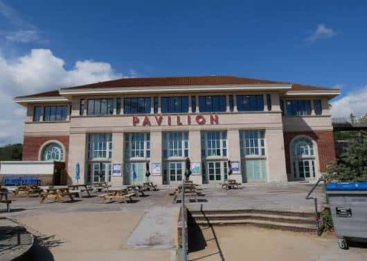 Vista exterior del Bournemouth Pavilion Theatre con su fachada neoclásica y el nombre 'PAVILION' en letras rojas