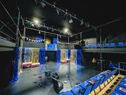 Escenario decorado con luces y cortinas azules para evento