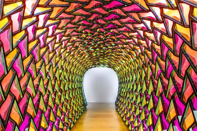 Túnel artístico con paredes de formas geométricas en colores vibrantes