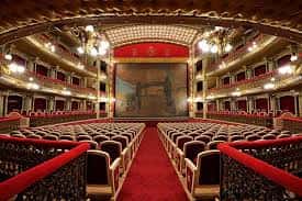 Interior del auditorio del Teatro Romea con butacas rojas, balcones ornamentados y escenario