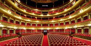 Planta baja del auditorio del Teatro Romea, mostrando filas de butacas rojas y balcones curvos