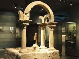 Estructura arquitectónica romana en exhibición: arco y columnas sobre base de piedra