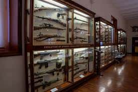Interior del museo con vitrinas de armas y uniformes militares