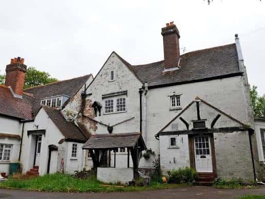 Vista exterior del Wymering Manor mostrando su arquitectura tradicional con fachada blanca y tejados de tejas