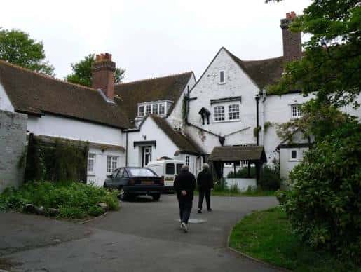 Entrada al Wymering Manor con personas caminando hacia el edificio principal