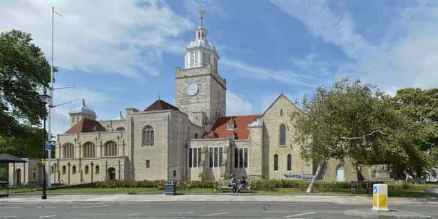 Vista exterior de Portsmouth Cathedral con su torre central y reloj bajo un cielo azul